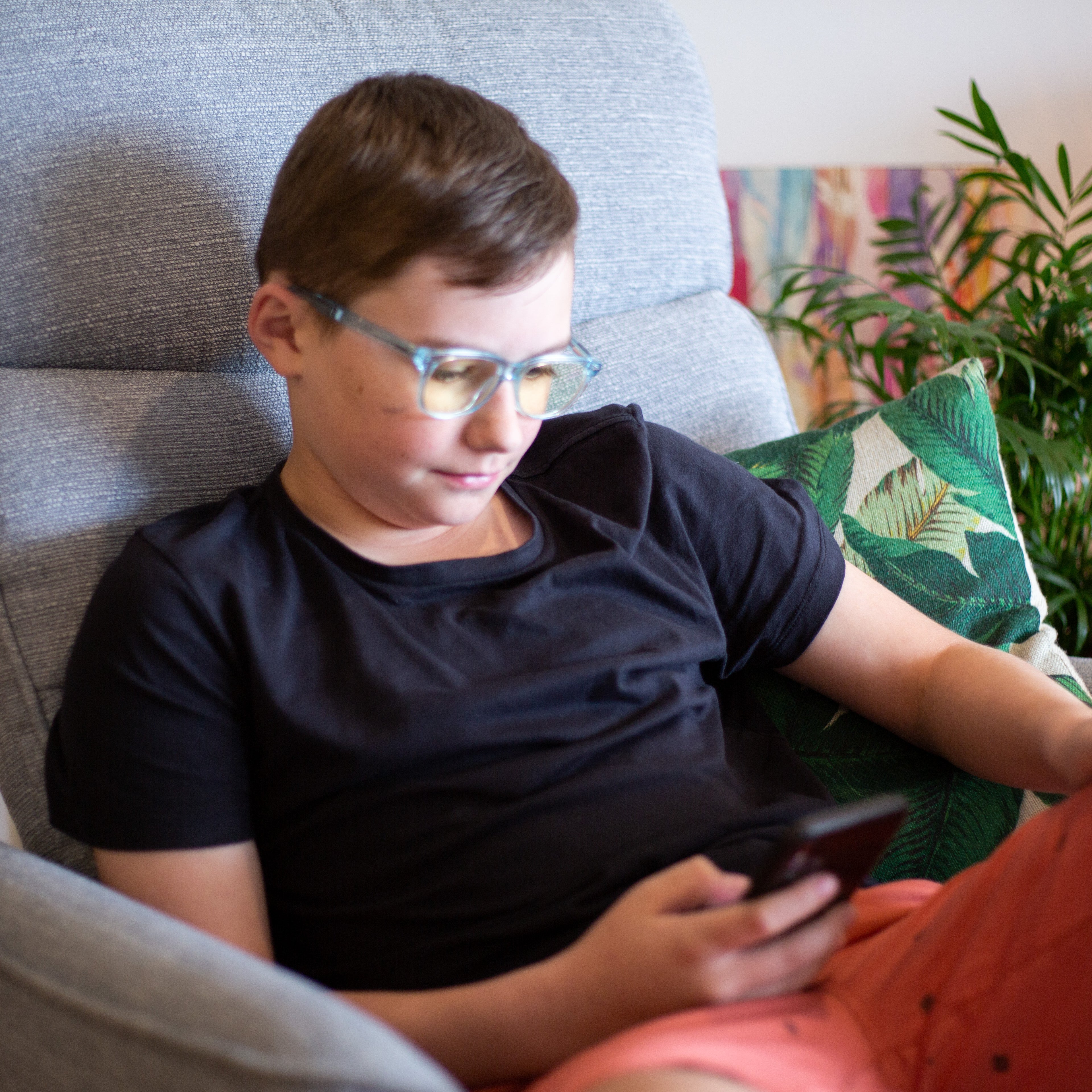 Boy wearing Focus Swannies Crystal Aquamarine blue light glasses