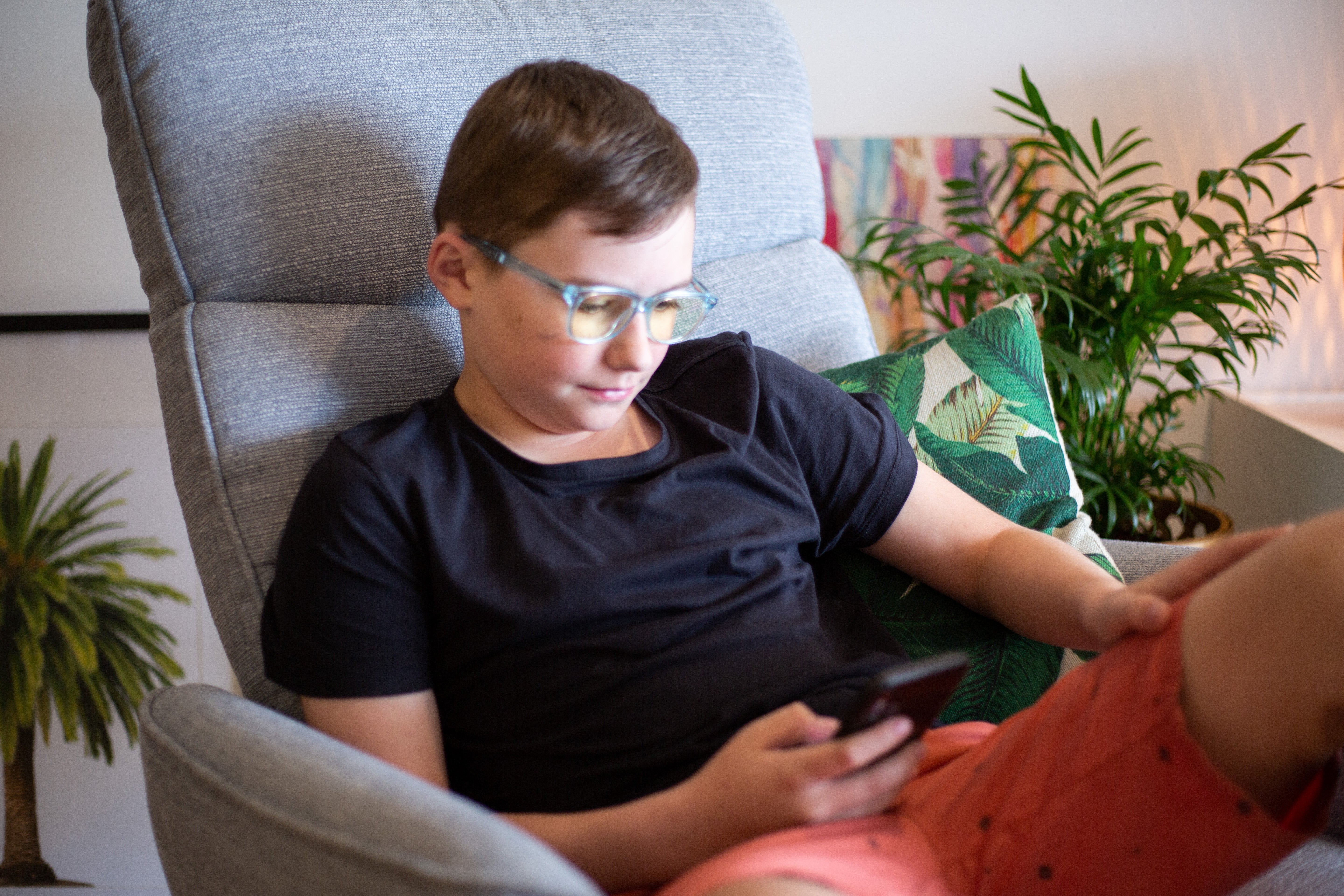 Boy wearing Focus Swannies Crystal Aquamarine blue light glasses